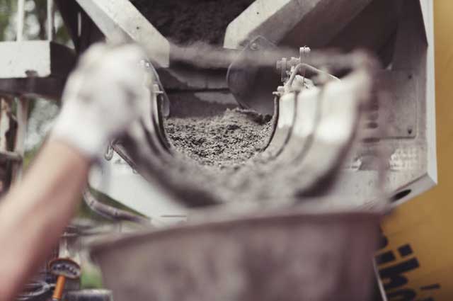 Photo of cement mixer dispensing cement into a funnel
